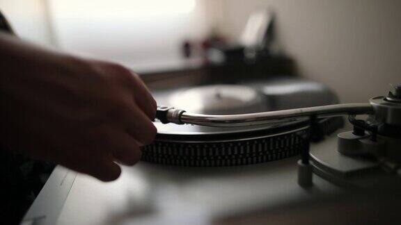 女人的手放置针在黑胶唱片的特写