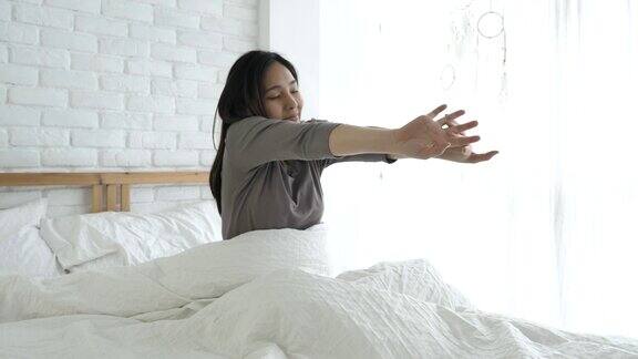 早上醒来后女人在床上伸懒腰