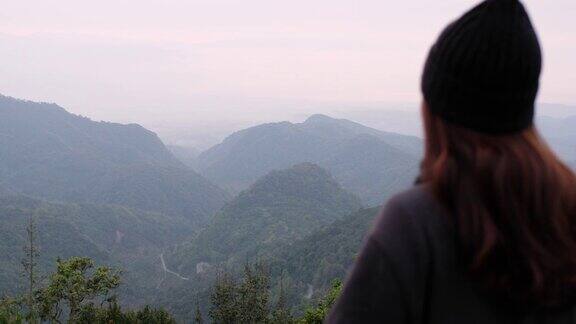 模糊的后视图一个女性旅行者站在看一个美丽的山景