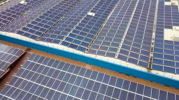 太阳能发电厂鸟瞰图与蓝色光伏板安装在工业建筑屋顶