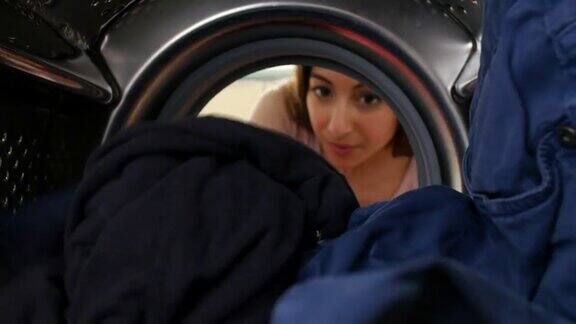 女人把衣服放进洗衣机