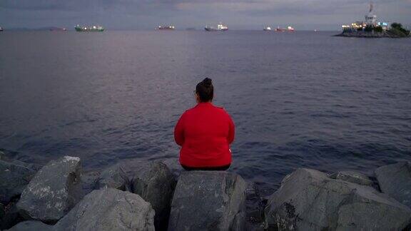一个身材高大的年轻女子独自站在土耳其伊斯坦布尔马尔马拉海的海滩上