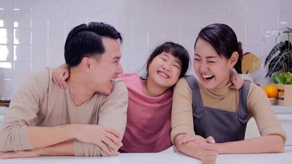 一个快乐的年轻家庭一个女孩对着镜头微笑现代家庭