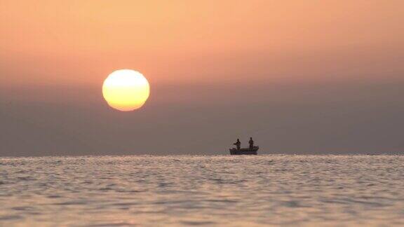 日出的海边漂浮着几艘渔船