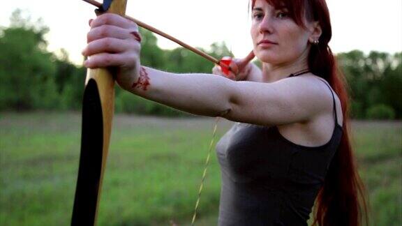 女性姜发弓箭手射击目标与她的弓和箭与自制的梅赫迪指甲花纹身在手上
