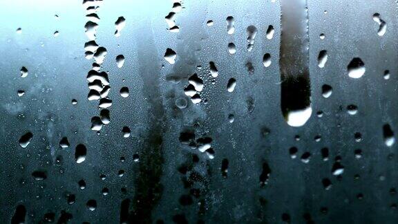 雨滴从冒着水汽的玻璃上落下