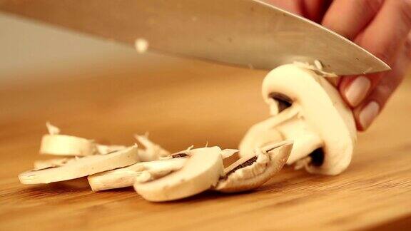用一把银刀在木盘上切蘑菇