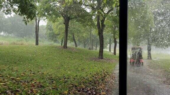 在下雨的日子里一群亚洲华人高尔夫球手和家人驾驶着高尔夫球车穿过高尔夫球场被水淹没的车道