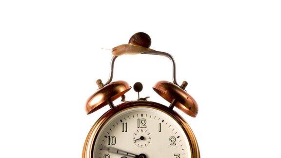 时钟手旋转快的时间流逝时钟指针快速旋转在古董青铜闹钟上的白色背景