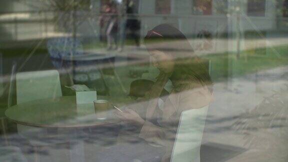 一名女子在咖啡馆用智能手机上的应用程序边喝咖啡边笑边发短信