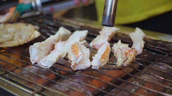 烤海鲜蟹腿和扇贝在日本街头小吃市场烤