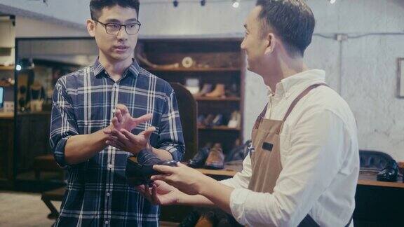 亚洲男性顾客在鞋店买鞋(慢镜头)