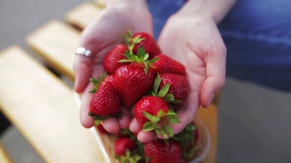 一个漂亮女人手里拿着新鲜成熟的草莓