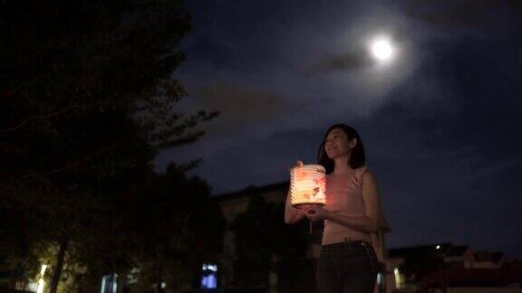 亚洲华人妇女手持纸灯笼行走庆祝节