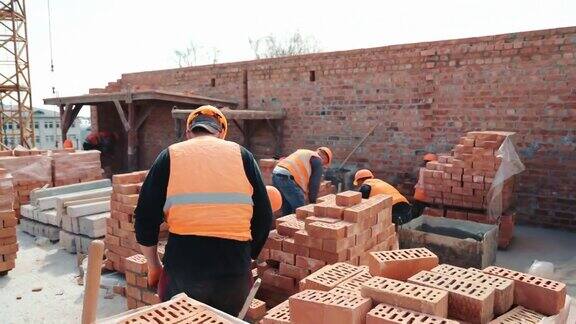 建筑者正在建造砖墙施工中的施工工作主人们铺砖砌墙