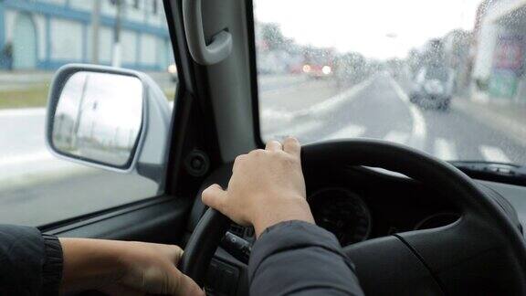 女人在下雨的时候手握方向盘开车