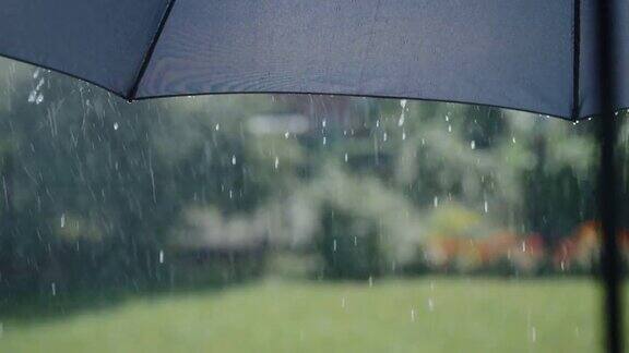 阳光明媚的夏雨水珠从灰色的伞面上流下来