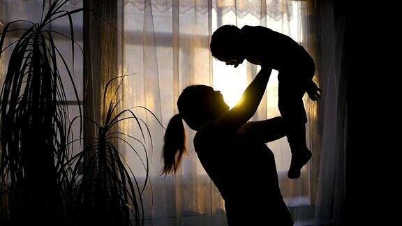 一个女孩在窗边和一个婴儿玩