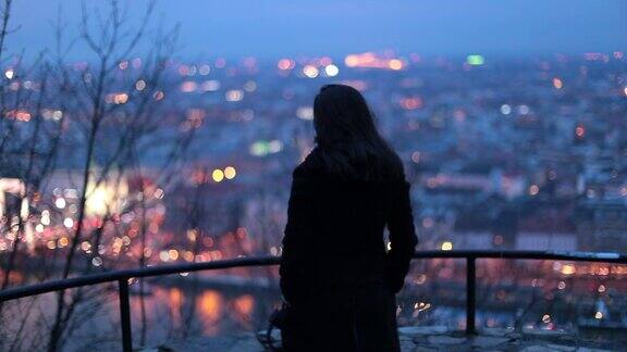 女人看城市夜景夜深人静的人在看城市风景的同时思考生活