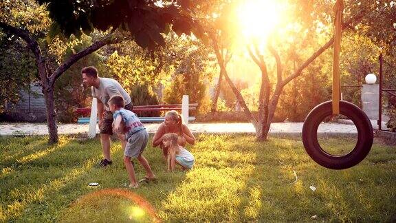 父母与狗和孩子在自家后院玩耍