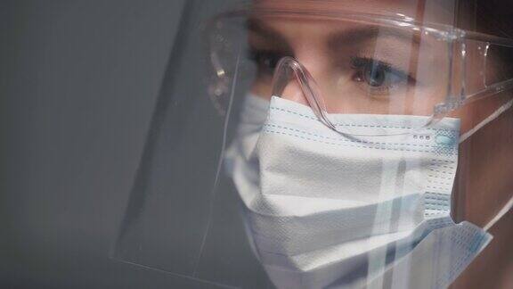 年轻女医生或护士工作戴着医用口罩眼镜和盾牌的女孩