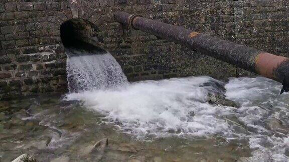 冬天山的河床里山道下漂浮的水供水管道跨越河流