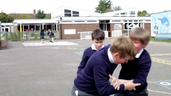 三个男孩在学校操场打架