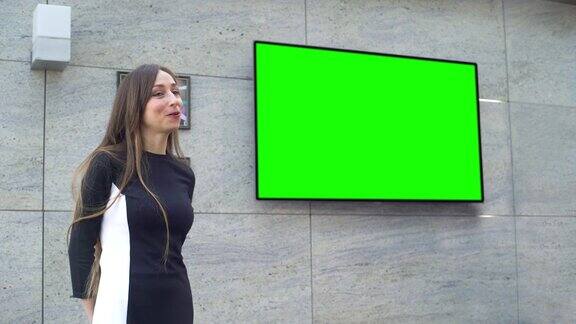 年轻的女商人在绿色大屏幕上做演讲