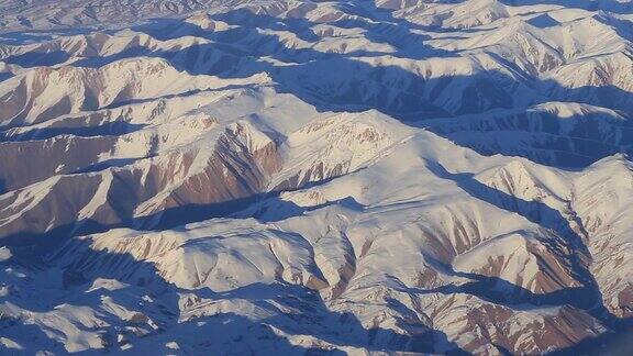 山上的鸟瞰图从飞机窗口观看阿富汗的兴都库什山脉