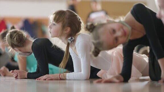 可爱的白人女孩与孩子们站在舞蹈室的平板姿势肖像自信的小舞者热身训练前在舞蹈学校室内芭蕾和艺术概念