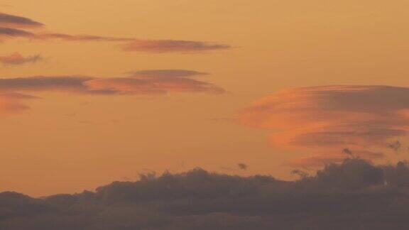 日落时分黄色天空上快速移动的云朵