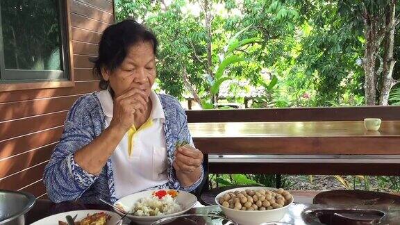 正在吃午饭的亚洲老年妇女