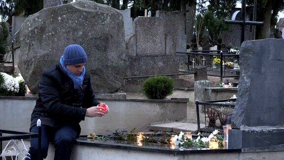父亲在墓地的女儿墓上放了蜡烛