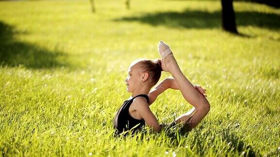 女孩在草地上做体操动作