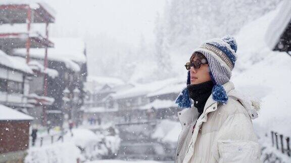 4K年轻的亚洲男子在下雪天在银山温泉区旅行
