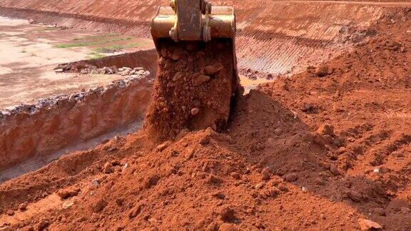 图为挖掘机铲斗在阳光下挖土的慢镜头
