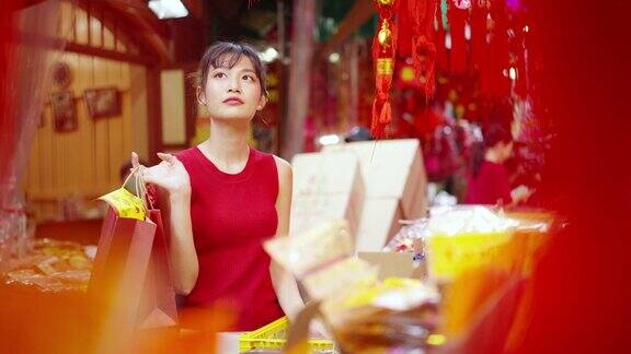 4K亚洲妇女在唐人街市场购买庆祝中国农历新年的装饰饰品