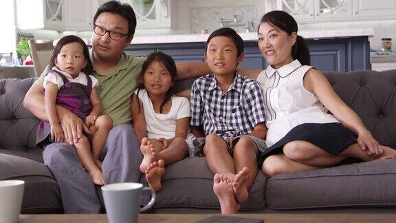 家人坐在家里的沙发上看R3D拍摄的电视