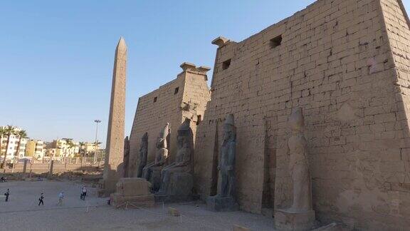 卢克索神庙入口拉美西斯二世雕像和尖塔游客进入埃及神庙