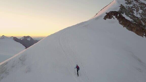 日出时登山运动员到达山顶的鸟瞰图