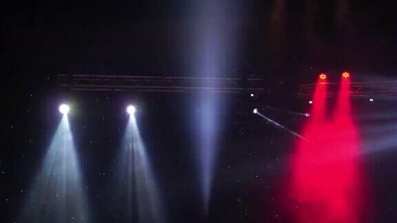 4K镜头的舞台灯光和聚光灯音乐会移动在黑暗的背景娱乐和音乐