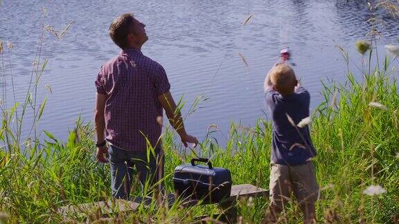 父亲和儿子在湖边钓鱼