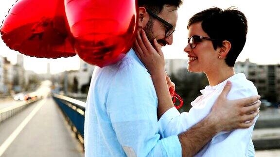 微笑的情侣在日落与气球相爱