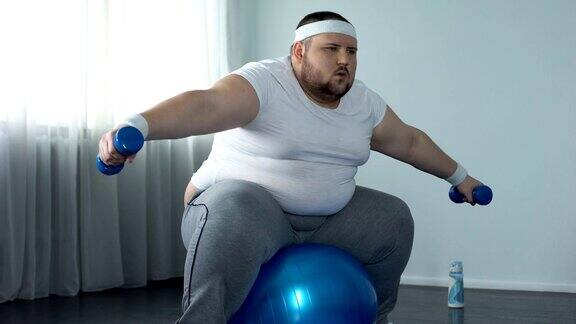 虚弱肥胖的男性挣扎着举起哑铃缺乏体育活动饮食