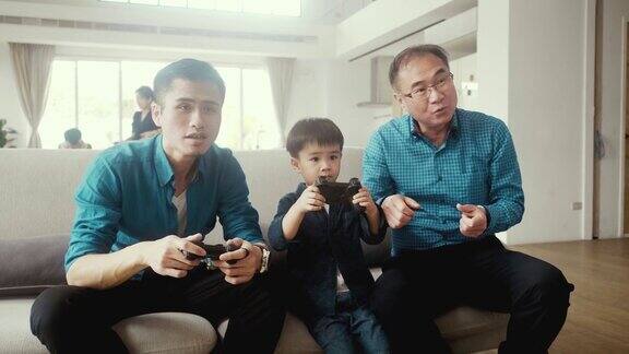 爷爷爸爸和儿子一起玩电子游戏