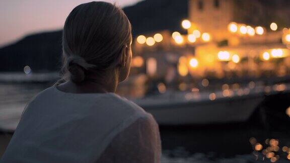 黄昏时分克罗地亚一名年轻女子在宁静的港口休息