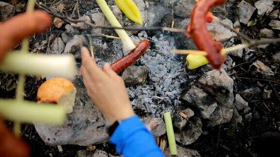 在森林里烧烤香肠男人在烤香肠