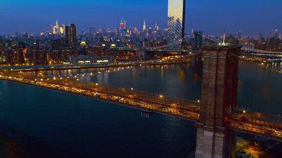 从布鲁克林大桥上鸟瞰曼哈顿的交通以曼哈顿中城的为背景在夜晚被照亮无人机视频与广泛的轨道摄像机运动
