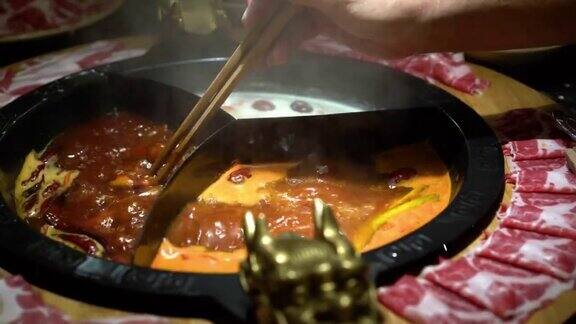在中国的麻辣火锅汤里煮一片生猪肉