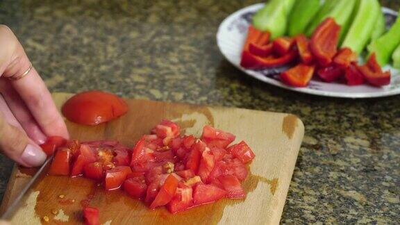 女人们用菜刀在木制砧板上切新鲜的西红柿